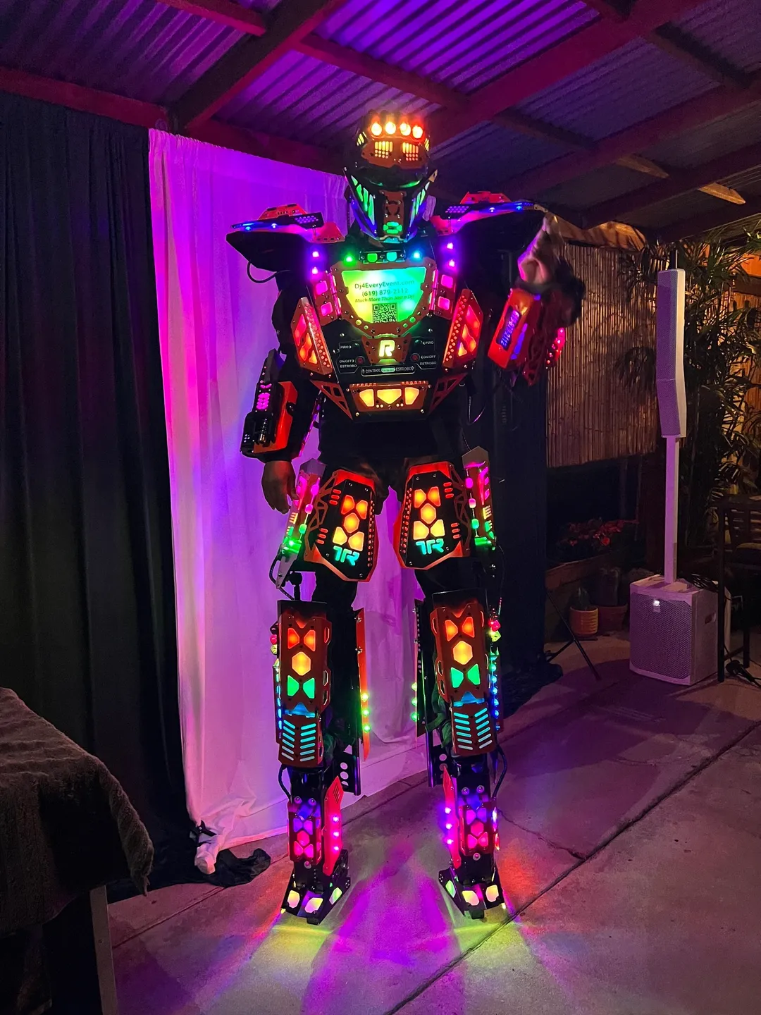 A robot that is lit up and standing on it's hind legs.